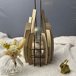 Lampe en bois dubaï, couleur brute avec sa propre ampoule éteinte. Posée sur une nappe en velour à côté d'un lapin 3D et d'un vase avec des fleurs en bois