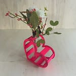 Décoration coeur "Adoration" en bois en rose. C'est un coeur qui accueil en son centre un petit vase pour y mettre des fleurs. Le coeur est un peu décalé et en plan large.