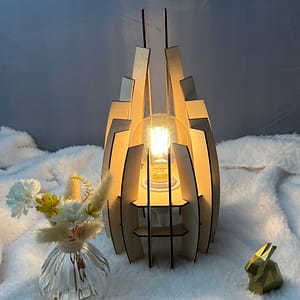 Lampe en bois dubaï, couleur brute avec sa propre ampoule. Posée sur une nappe en velour à côté d'un lapin 3D et d'un vase avec des fleurs en bois