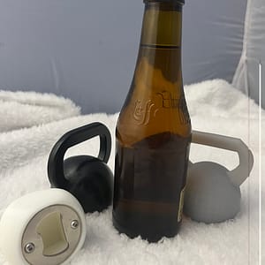 Décapsuleur Kettlebell en 3D avec une bière. Il y en a 3 qui sont posés sur nappe en velours