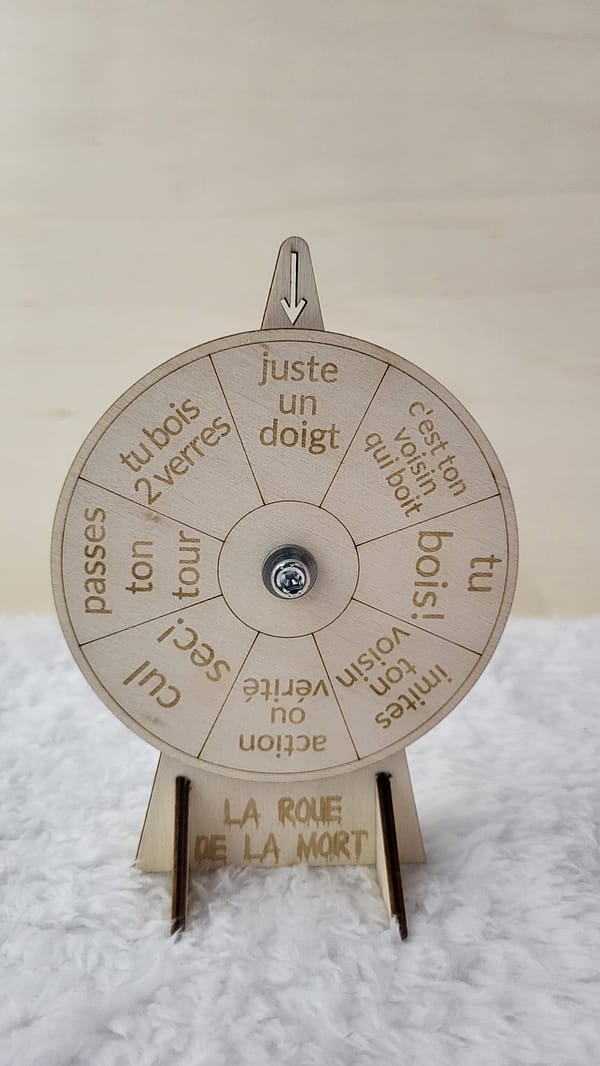 Roue de la mort en bois, avec 8 gages différents gravés. Installé de face sur une nappe en velour