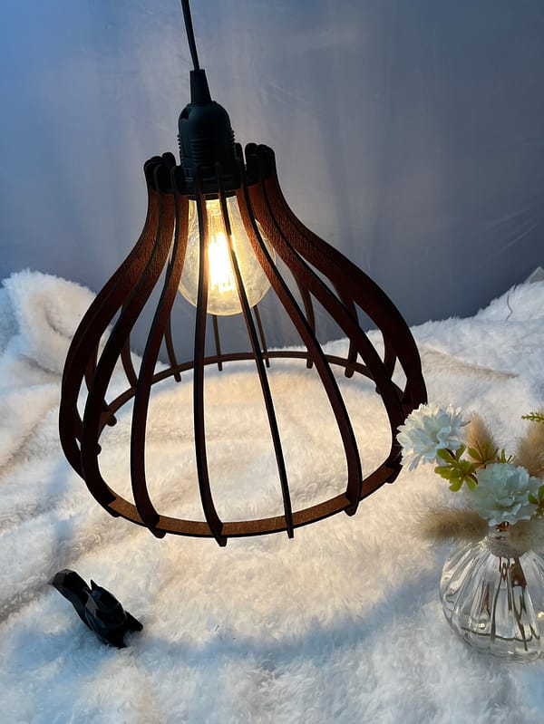 Suspension en bois Boréa couleur acajou, avec on ampoule allumé. Disposée au-dessus d'une nappe en velour et à côté d'un écureuil en 3D et d'un vase en verre