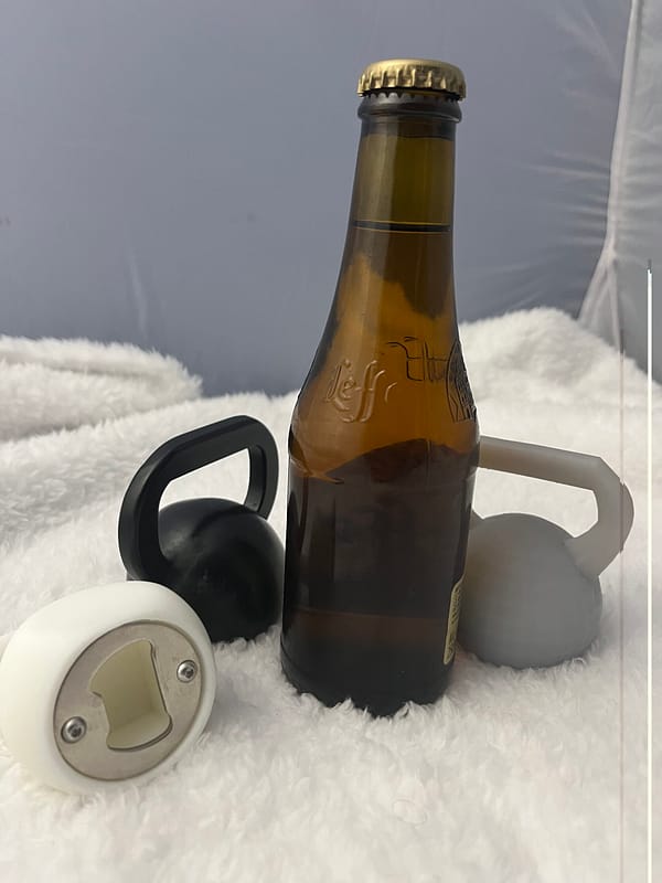 Décapsuleur Kettlebell en 3D avec une bière. Il y en a 3 qui sont posés sur nappe en velours