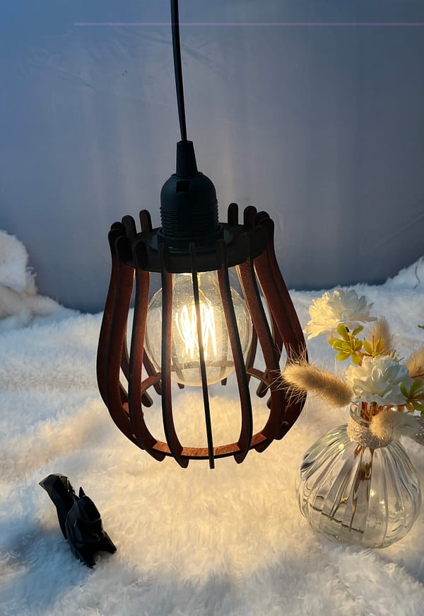 Baladeuse en bois Woom, avec son ampoule allumée. Disposée sur une nappe en velour et à côté d'un écureuil en 3D et d'un vase en verre